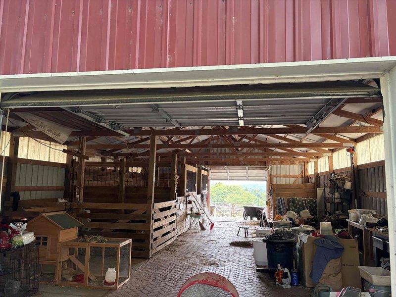 Conducted on-site assessment of barn facility to provide electrical estimate for exhaust fan installation. Evaluated existing ceiling structure, including exposed wooden beams, metal roofing, and current ventilation system with black flexible ductwork. Assessed electrical infrastructure and determined optimal placement for exhaust fan unit to improve air circulation in the agricultural workspace housing livestock and equipment storage areas.