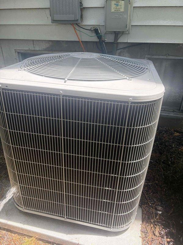 Completed preventive maintenance tune-up on residential split system air conditioning unit with outdoor condenser located on ground-level concrete pad. Performed comprehensive system inspection including visual examination of condenser cabinet, coil fins, and electrical components. Verified proper electrical operation with amperage readings showing 48.2 amps at compressor circuit using clamp meter. Inspected disconnect box and electrical connections for secure terminations and proper wire routing. Cleaned debris including organic material from base of unit and surrounding area. Confirmed condenser fan operation, adequate clearances from structure, and overall system functionality. Unit operating within normal parameters upon completion of tune-up service.