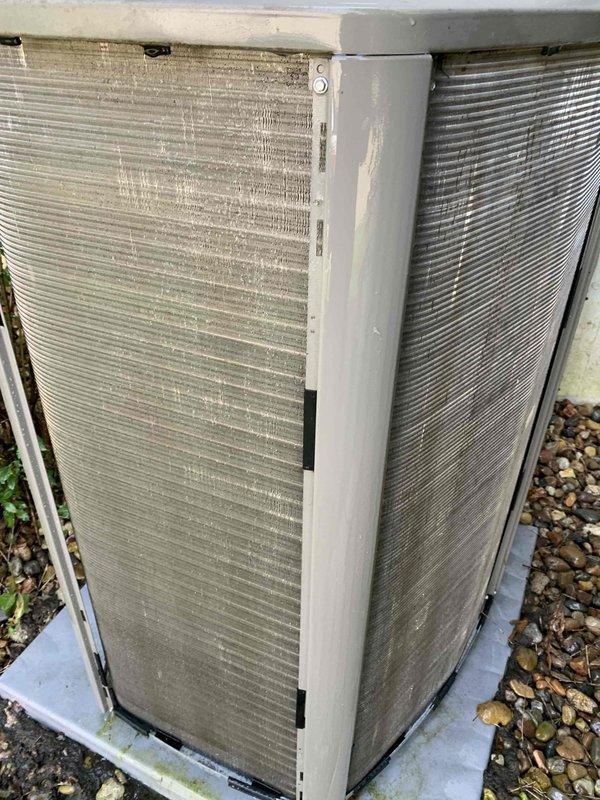 Responded to follow-up call for frozen air conditioning unit. Upon arrival, inspected outdoor condensing unit and found heavily soiled condenser coils with significant dirt and debris accumulation restricting airflow. Documented unit condition with photos showing approximately 10-year-old system installed on side of home with visible buildup on heat exchanger fins. Recommended coil cleaning and further diagnostics to address freezing issue and restore proper system operation.