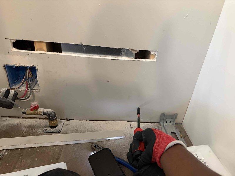 Installed dedicated 240V circuit using 12/4 wire for electric stove connection. Ran new wiring through wall cavities, cut access openings to route conductors, and installed appropriate electrical boxes and connections. Completed installation with proper shutoff and outlet configuration to meet code requirements for kitchen appliance circuit.