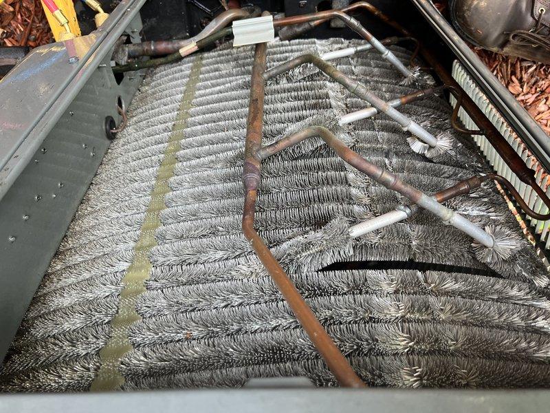 Responded to no cooling complaint on backyard ground-mounted unit U10. Upon inspection, found evaporator coil heavily contaminated with dust and debris accumulation, restricting airflow and reducing cooling capacity. Coil fins showed significant buildup with biological growth staining and residue visible on aluminum fin surfaces. Performed thorough coil cleaning to remove accumulated debris and restore proper airflow through the system. Verified refrigerant lines and connections showed normal patina with no visible leaks. System airflow restored to manufacturer specifications following cleaning procedure.