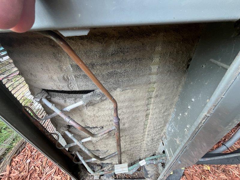 Responded to no cooling complaint on backyard ground-mounted unit U10. Upon inspection, found evaporator coil heavily contaminated with dust and debris accumulation, restricting airflow and reducing cooling capacity. Coil fins showed significant buildup with biological growth staining and residue visible on aluminum fin surfaces. Performed thorough coil cleaning to remove accumulated debris and restore proper airflow through the system. Verified refrigerant lines and connections showed normal patina with no visible leaks. System airflow restored to manufacturer specifications following cleaning procedure.