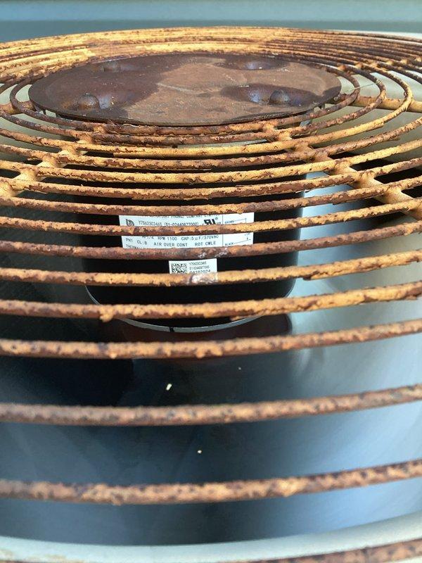 Replaced failed condenser fan motor with new 1/4 HP, 1100 RPM unit rated for 208-230V operation with 5µF capacitor. Removed and disposed of defective motor, installed replacement on condenser unit featuring ball bearings, CWLE rotation, and 48Y frame configuration, restoring proper airflow across condenser coils which showed signs of oxidation and weathering.