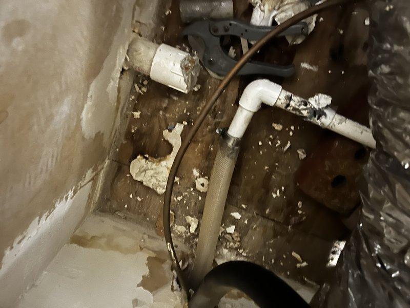 Responded to callback for condensate drain leak affecting kitchen area on recently installed system less than one month old. Upon inspection, discovered improperly secured condensate drain line with debris accumulation in drain pan area beneath unit. Cleared debris, re-secured PVC drain connections, verified proper pitch and flow, and confirmed ceiling water staining had ceased with no active leakage present.