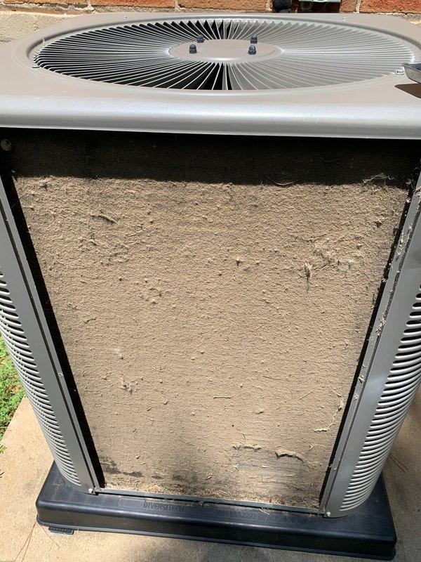 Responded to service call for rattling noise coming from 10-year-old basement air conditioning unit. Upon arrival, inspected outdoor condenser unit and found heavy accumulation of dirt and debris on front panel and internal components. Removed access panel and thoroughly cleaned condenser coils, fan assembly, and housing. Identified loose mounting hardware on blower fan causing vibration and rattling noise audible through ductwork. Tightened all fasteners and secured fan assembly. Cycled system through multiple operation cycles to verify elimination of rattling noise. Unit operating properly with normal airflow and cooling capacity restored.