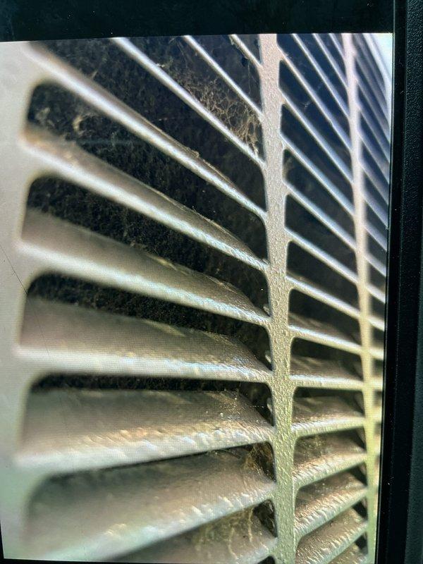 Responded to follow-up service call for frozen air conditioning system. Upon arrival, performed comprehensive diagnostic assessment of both indoor and outdoor components. Inspection revealed heavily restricted airflow due to significant dust and debris accumulation on return air grille, which contributed to system freeze-up condition identified during previous visit. Cleaned and cleared ventilation grille to restore proper airflow. Inspected outdoor condensing unit and verified operational status of compressor and fan assembly. System airflow restored to manufacturer specifications, allowing unit to operate within normal temperature parameters without freezing.