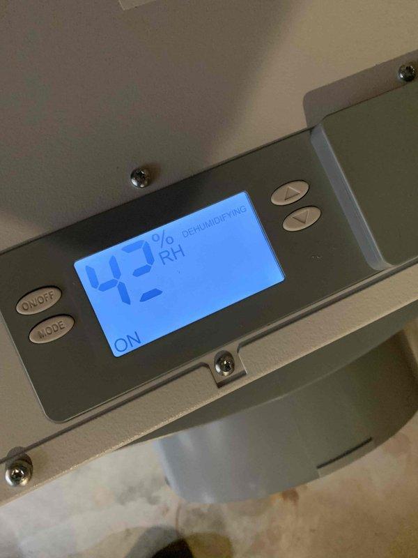 Installed freeze stat on new HVAC unit and completed dehumidifier installation in unfinished basement area. Dehumidifier was positioned on concrete floor with ductwork connection and wall-mounted digital control panel displaying humidity readings and operational status. Documentation photos of equipment serial number and installed system were captured per service requirements.