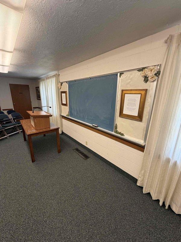 Completed electrical estimate for installation of outlet behind television in meeting room space. Assessment included determining optimal routing path for wiring through attic space and wire molding installation from ceiling level to outlet location. Documented existing conditions including wall configuration, ceiling access points, and room layout to provide accurate scope for power installation behind wall-mounted display.