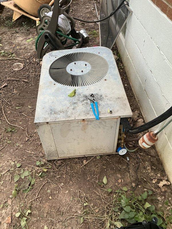 Responded to no cooling complaint on 10+ year old outdoor condenser unit in backyard. Upon arrival, indoor temperature was 87 degrees with thermostat displaying error code. Unit had been shut down for three days prior to service call. Performed diagnostic evaluation of condenser unit, which showed significant weathering, dirt accumulation, and corrosion on refrigerant lines and copper fittings. Outdoor fan operational but system not providing adequate cooling. Documented equipment condition with photos showing debris accumulation around unit base and corrosion on service valves requiring attention.
