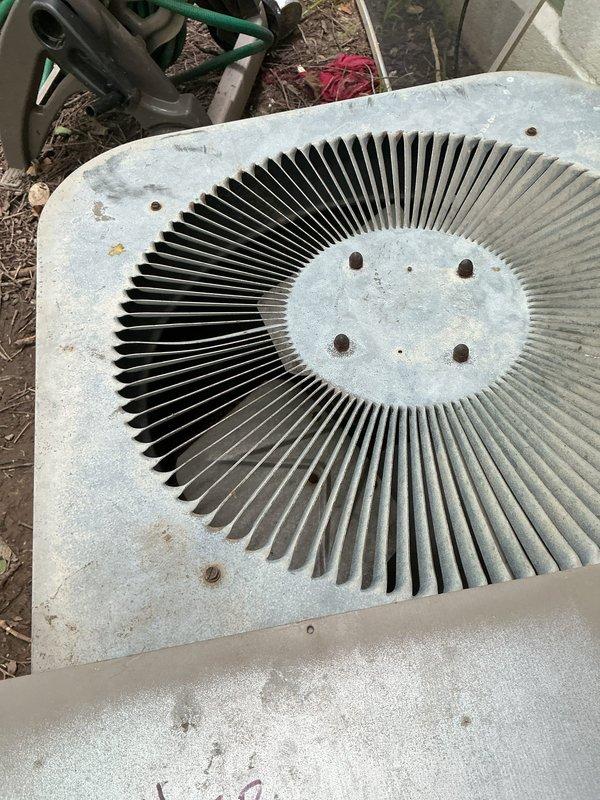 Responded to no cooling complaint on 10+ year old outdoor condenser unit in backyard. Upon arrival, indoor temperature was 87 degrees with thermostat displaying error code. Unit had been shut down for three days prior to service call. Performed diagnostic evaluation of condenser unit, which showed significant weathering, dirt accumulation, and corrosion on refrigerant lines and copper fittings. Outdoor fan operational but system not providing adequate cooling. Documented equipment condition with photos showing debris accumulation around unit base and corrosion on service valves requiring attention.