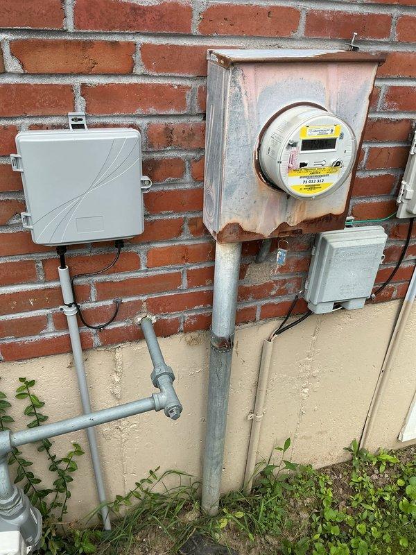 Conducted on-site electrical assessment for installation of new 200-amp main service panel and 100-amp subpanel, along with five to six additional outlets in the garage. Evaluated existing exterior electrical infrastructure, including weathered meter housing showing significant rust and corrosion on mounting components and enclosure. Documented current service configuration, conduit routing, and utility connection points to develop comprehensive installation estimate for panel upgrades and garage circuit expansion.