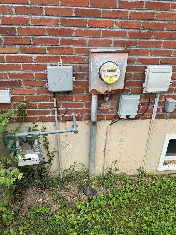 Conducted on-site electrical assessment for installation of new 200-amp main service panel and 100-amp subpanel, along with five to six additional outlets in the garage. Evaluated existing exterior electrical infrastructure, including weathered meter housing showing significant rust and corrosion on mounting components and enclosure. Documented current service configuration, conduit routing, and utility connection points to develop comprehensive installation estimate for panel upgrades and garage circuit expansion.