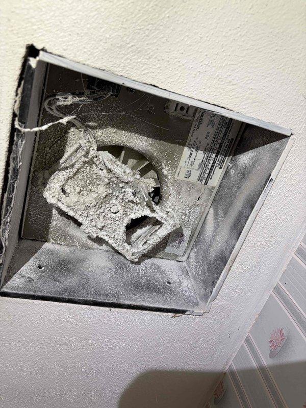 Responded to service call for non-operational bathroom exhaust fan on main floor. Upon inspection, found fan unit heavily clogged with significant dust and lint accumulation on blades, housing, and interior ductwork surfaces. Removed vent cover to access fan assembly and assessed mechanical components. The excessive debris buildup was preventing proper fan operation and restricting airflow through the ventilation system, creating a potential fire hazard and compromising bathroom ventilation efficiency.