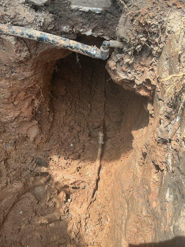 Excavated approximately 48 inches down in front of the porch to expose the water service line and successfully located the leak in the corroded galvanized pipe. Replaced approximately 6 feet of deteriorated water service line from the excavation point toward the foundation. Tunneled beneath the porch structure as necessary to complete the repair and establish proper connection to the foundation. Backfilled the excavation site upon completion of the water line replacement, with excess spoils mounded on-site to allow for settling in the tunneled areas. Restored landscaping to the extent possible following the completion of the underground utility repair.