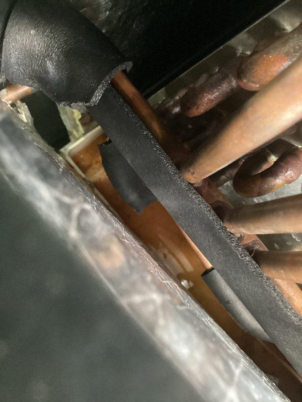 Responded to callback for ongoing water leak from 2023 air conditioning system that persisted after previous technician visit. Upon inspection, identified condensate drain line issue with improper connection at drain pan outlet. Found corroded drain fitting and partially obstructed drain hose causing water backup and overflow. Cleaned drain line, replaced faulty threaded coupling and drain hose connection, verified proper drainage flow, and tested system operation to confirm leak resolution.