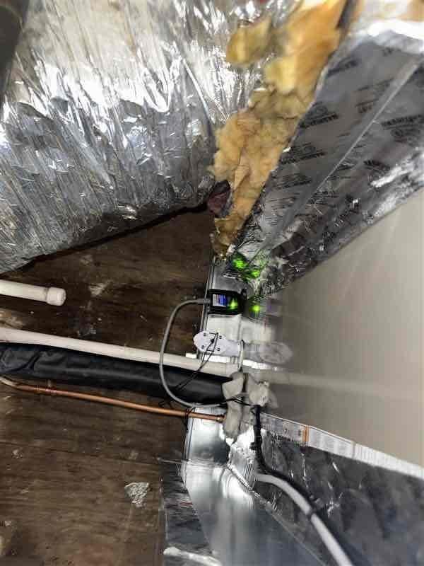 Completed callback for no cooling issue on Bryant system. Installed new slab coil in existing location without modifying existing ductwork per specifications. Installed Honeywell thermostat, drain pan wet switch safety float switch, new SS2 disconnect with whip. Installed condensate drainage system with PVC piping and safety monitoring device with digital display and indicator lights visible in attic installation. All refrigerant lines properly insulated and routed through attic space. System tested and operational upon completion.