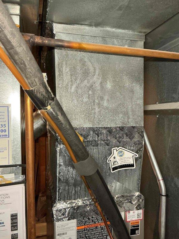 Responded to no cooling call with reported water leaking from furnace unit in basement. Upon arrival, found excessive condensation on air handler and ductwork due to inadequate insulation on cold surfaces in humid environment. The condensation had triggered the safety float switch, shutting down the cooling system as designed to prevent water damage. Verified drain line was clear and functioning properly. Inspected evaporator coil and confirmed normal operation with no refrigerant leaks. System had been operating in high humidity conditions causing moisture accumulation on uninsulated metal surfaces of plenum and supply ductwork. Recommended additional insulation be applied to all exposed cold air ductwork and plenum surfaces to prevent future condensation issues. Emptied safety pan, reset float switch, and restored system to normal cooling operation. Verified proper airflow and temperature split across evaporator coil. System operating as designed with adequate cooling capacity. Advis
