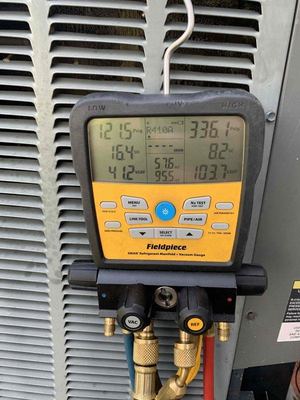 Arrived on-site following previous day's diagnostic where system was found frozen. Performed system evaluation under extreme heat conditions with ambient temperatures reaching 99°F. Utilized Fieldpiece SMAN manifold gauge to assess refrigerant pressures and temperatures on R-410A system, recording high-side pressure at 336.1 PSIG with superheat at 161°F and subcooling readings. Documented system operating parameters and current conditions for repair recommendations, which will require additional authorization to proceed.