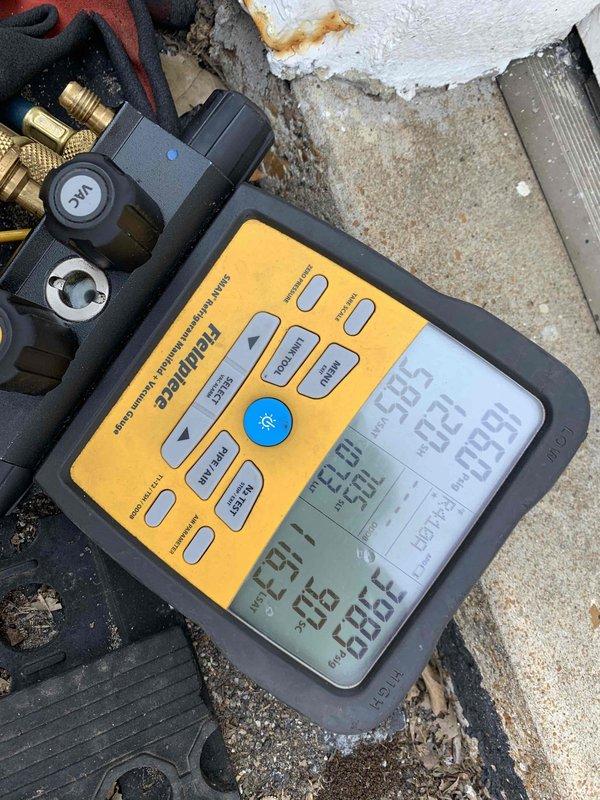 Responded to no cooling complaint on 1-year-old Bryant system located in attic. Upon arrival, contacted customer as requested and confirmed unit was powered off. Accessed attic-mounted equipment with ladder. Performed diagnostic evaluation using Fieldpiece digital manifold and refrigerant scale to assess system pressures, temperatures, and refrigerant charge. Testing revealed system was low on refrigerant, indicating a leak in the system. Documented readings and equipment conditions with photos showing measurement devices and condenser unit. Advised customer of findings and provided recommendations for leak detection service and refrigerant recharge to restore proper cooling operation.