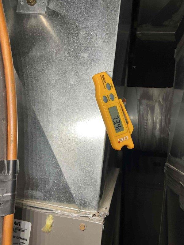 Responded to no-cool complaint on aging residential cooling system located in side yard. Upon arrival, performed diagnostic temperature measurements on supply ductwork, recording 88.8°F supply air temperature, indicating inadequate cooling performance. Conducted system evaluation and identified unit not maintaining thermostat setpoint. Verified blower operation and airflow through ductwork system. Performed tune-up service including system inspection and temperature diagnostics using calibrated instruments. Documented findings with thermal readings at multiple points on supply plenum and ductwork. Advised customer on system performance issues requiring additional repairs beyond standard maintenance to restore proper cooling capacity.