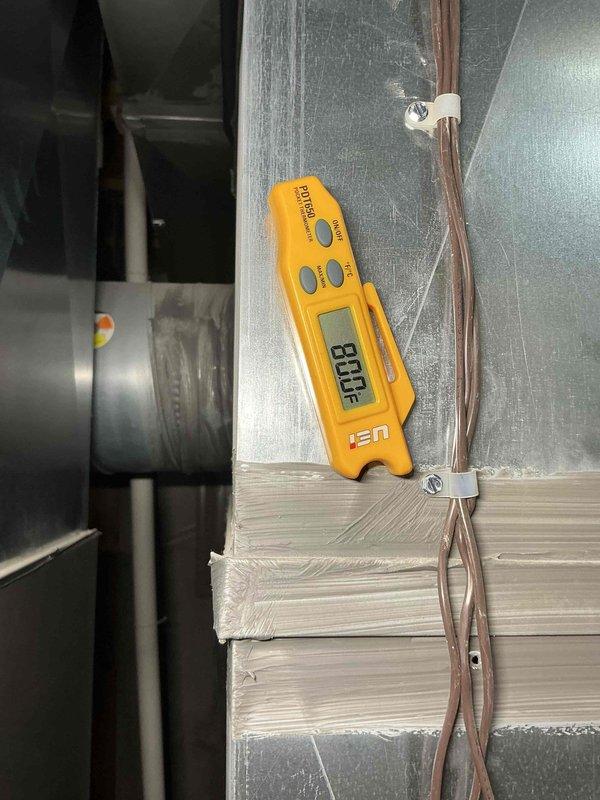Responded to no-cool complaint on aging residential cooling system located in side yard. Upon arrival, performed diagnostic temperature measurements on supply ductwork, recording 88.8°F supply air temperature, indicating inadequate cooling performance. Conducted system evaluation and identified unit not maintaining thermostat setpoint. Verified blower operation and airflow through ductwork system. Performed tune-up service including system inspection and temperature diagnostics using calibrated instruments. Documented findings with thermal readings at multiple points on supply plenum and ductwork. Advised customer on system performance issues requiring additional repairs beyond standard maintenance to restore proper cooling capacity.