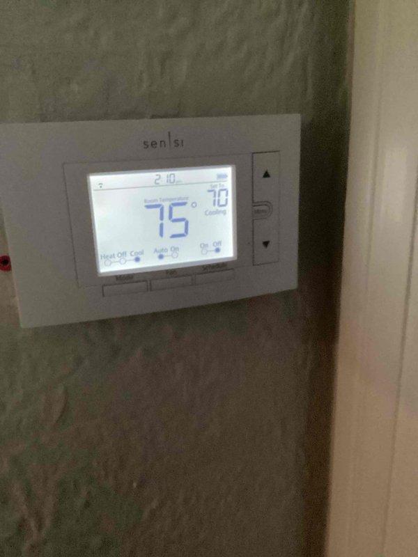 Responded to no cooling complaint where system was struggling to maintain temperature. Upon arrival, found thermostat displaying 75°F setpoint with actual indoor temperature reading 76°F, indicating unit was running but not achieving desired cooling. Inspected outdoor condenser unit located on ground level beside residence in ivy ground cover. Performed diagnostic evaluation of cooling system, checked refrigerant levels, electrical connections, and airflow. System restored to proper operation with indoor temperature brought down to setpoint. Unit tested and verified cooling cycle functioning correctly before departure.