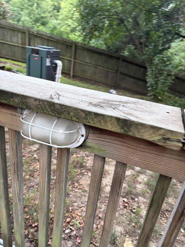 Installed new electrical circuit and outdoor lighting fixture on existing deck structure. Routed black electrical cable along deck railing system and mounted junction box to vertical post for proper connection and code compliance. Successfully completed wiring installation with all components secured and operational.
