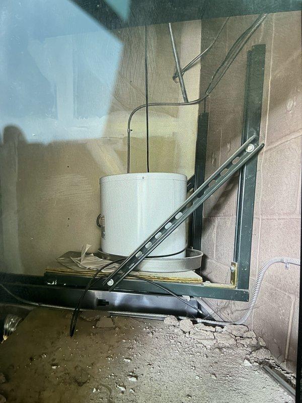 Responded to commercial water heater leak located above ceiling in bathroom area. Removed failed 20-gallon electric water heater from ceiling-mounted installation and replaced with new 7-gallon electric unit. Accessed work area via ladder through ceiling opening, navigated confined attic space with existing mechanical equipment and framing. Connected electrical supply, installed water supply lines, and verified proper operation of new compact water heater. Cleaned work area and removed old unit from premises.