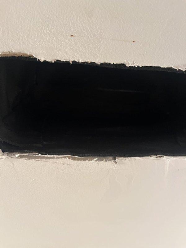 Responded to callback regarding improperly insulated ductwork causing condensation and water discharge from supply register. Upon arrival, removed register grille and inspected duct opening to assess insulation deficiencies. Documented conditions with photographs showing exposed duct penetration through wall assembly with inadequate vapor barrier and missing insulation wrap at termination point. Water intrusion confirmed as result of condensation forming on uninsulated metal duct surfaces in conditioned space. Identified installation deficiency requiring proper duct insulation and sealing to prevent future moisture issues and maintain system efficiency.