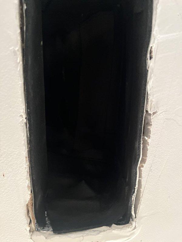 Responded to callback regarding improperly insulated ductwork causing condensation and water discharge from supply register. Upon arrival, removed register grille and inspected duct opening to assess insulation deficiencies. Documented conditions with photographs showing exposed duct penetration through wall assembly with inadequate vapor barrier and missing insulation wrap at termination point. Water intrusion confirmed as result of condensation forming on uninsulated metal duct surfaces in conditioned space. Identified installation deficiency requiring proper duct insulation and sealing to prevent future moisture issues and maintain system efficiency.