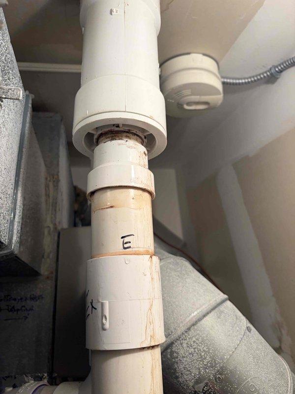 Responded to service call for reported humidifier leak in upstairs closet. Upon inspection, identified active water leakage from humidifier supply line connections causing visible ceiling staining and discoloration in adjacent areas. Discovered corroded PVC pipe joints with rust-colored staining at multiple connection points beneath the humidifier unit, indicating prolonged moisture exposure and deteriorated seals. Documented water damage evidence on ceiling surfaces near HVAC register and compromised plumbing connections. Provided customer with repair recommendations and photographed affected areas for documentation purposes.