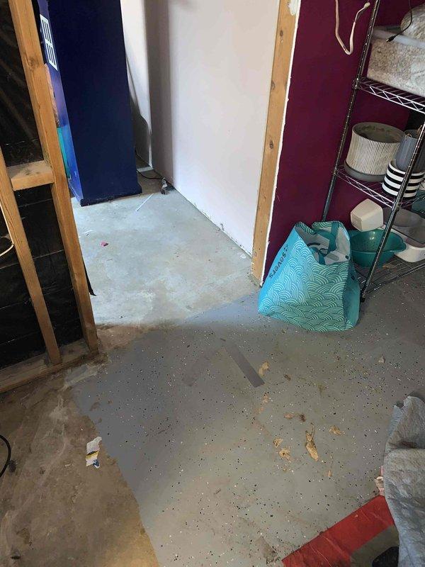Performed camera location service in unfinished basement area to identify plumbing infrastructure within wall framing and concrete floor system. Documentation captured showing exposed wooden stud framing with foam insulation panels and utility connections, along with concrete floor surface conditions in renovation space requiring plumbing system assessment.