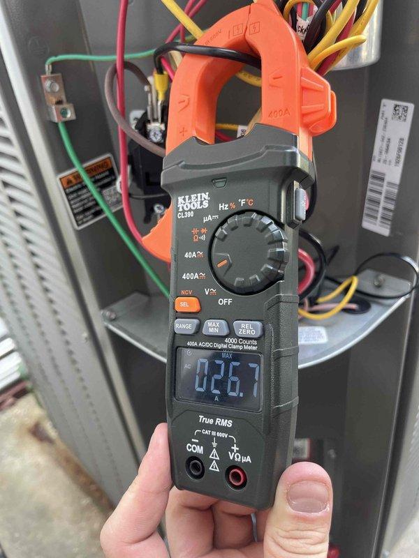 Installed soft start kit on residential outdoor HVAC unit to reduce startup current and improve compressor performance. Verified proper electrical connections, tested amperage draw at 26.7 amps using digital clamp meter, and confirmed all components functioning correctly after installation.
