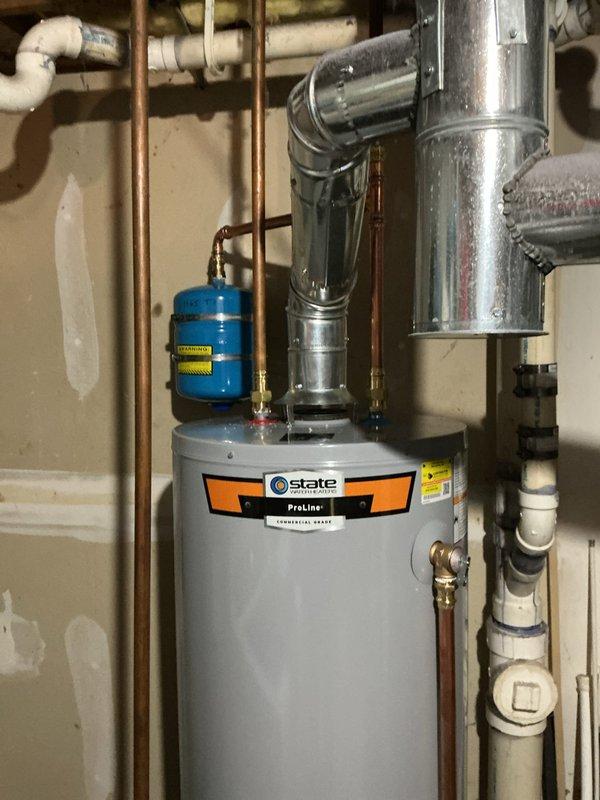 Completed installation of 40-gallon State ProLine commercial-grade gas water heater in residential utility room. Installed new 3/4-inch pressure reducing valve and blue expansion tank with proper copper piping connections and brass fittings to top of unit. Replaced two exterior hose bibs as requested on time and materials basis. Connected all hot and cold water supply lines using copper pipe with appropriate shut-off valves. Installed proper venting system with metal ductwork for exhaust gases. Verified all gas connections secure and tested unit for proper operation. All plumbing connections pressure tested and confirmed leak-free.