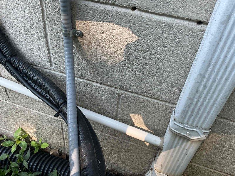 Responded to service call for mini split system leaking down interior wall. Upon inspection, identified improperly pitched condensate drain line on exterior of building causing water backup and overflow into living space. Corrected drain line pitch to ensure proper gravity drainage, verified condensate flow, and confirmed leak resolution with system operational test.