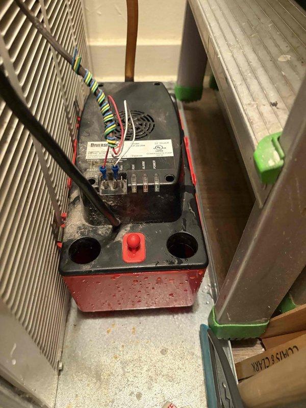 Completed inspection of residential HVAC system located in utility closet apartment unit. Verified proper operation of air conditioning system including control module, electrical connections, and safety components. Documented existing equipment condition with photographs showing control box with multi-wire connections, finned heat exchanger coils, and mounted Safe-T-Switch SS2 condensate overflow safety device on drain line. All components confirmed operational and system functioning as designed.