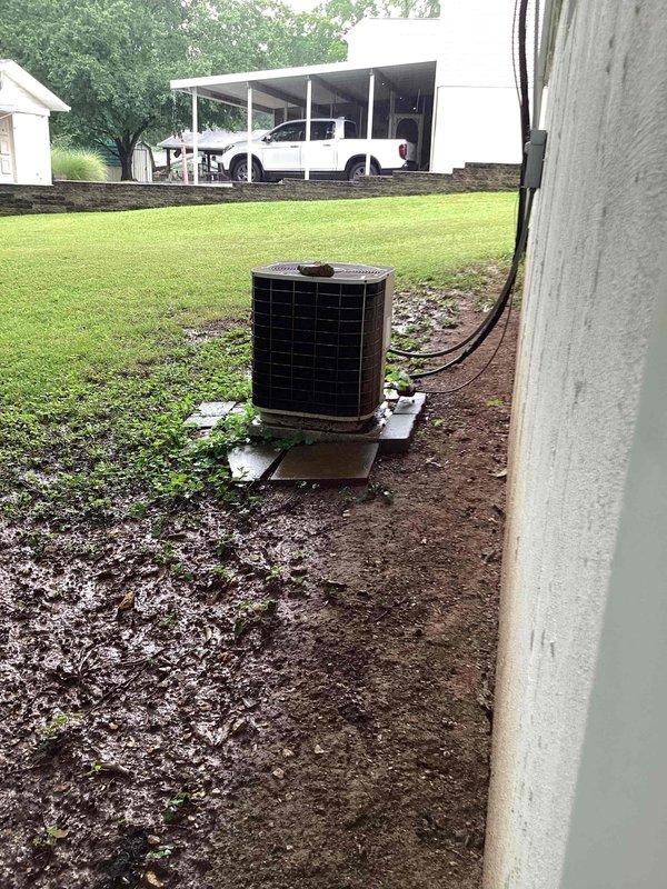 Responded to no-cool condition on 16-year-old residential air conditioning system with non-operational condenser fan motor. Upon arrival, performed comprehensive diagnostic evaluation of ground-level condenser unit and accessed internal components to assess blower motor, electrical connections, and refrigerant system integrity. Inspected wiring harness, capacitor, and motor windings; documented equipment condition with interior compartment showing accumulated debris in drain pan and exterior unit positioning in muddy soil conditions that may impact drainage and airflow efficiency.