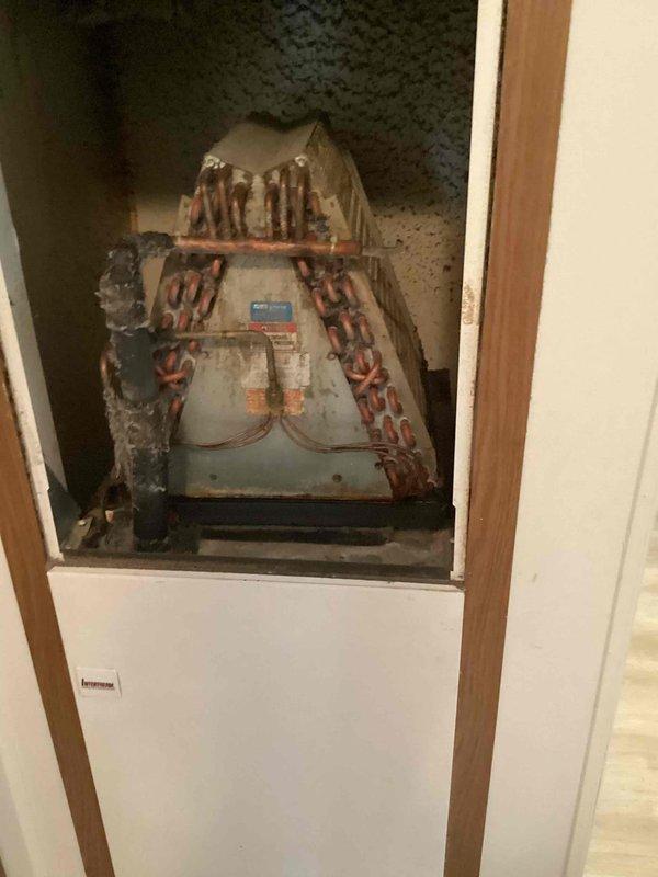 Responded to no cooling complaint on 10+ year old outdoor unit located at side of home. Upon arrival, found unit with significant exterior corrosion and deterioration consistent with age. Performed diagnostic evaluation of system components and thermostat operation, which was set to cooling mode with display reading 73°F. Verified fan operation per customer's pre-arrival instructions to leave fan running with AC off. Documented equipment condition showing extensive rust, paint degradation, and surface oxidation on compressor housing and associated hardware.