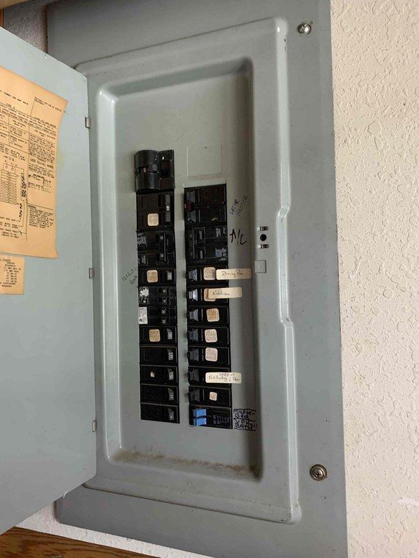 Completed comprehensive electrical panel assessment and provided estimate for full panel replacement. Documented existing panel configuration showing dual-column breaker arrangement with multiple circuits, including dedicated A/C circuit. Identified aging infrastructure evidenced by discolored documentation, worn interior surfaces, and outdated labeling system requiring modernization to meet current electrical code requirements.