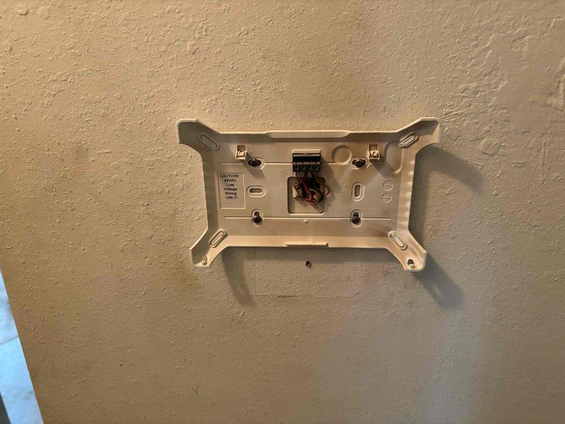 Responded to no-heat call with blank thermostat display in hallway location. Upon inspection, found failed thermostat with no power to display. Removed existing thermostat from wall plate, exposing wiring connections at mounting base. Installed new replacement thermostat control board and verified proper wiring connections to system. Tested unit operation and confirmed thermostat display functioning correctly and HVAC system responding to calls for heating and cooling.