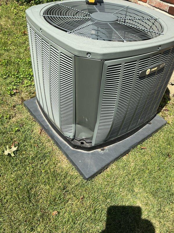 Responded to no cooling complaint on 10+ year old outdoor condenser unit. Upon arrival, found system blowing warm air with indoor temperature at 84 degrees. Performed diagnostic evaluation of outdoor unit located on ground-level concrete pad at side of residence. Opened access panel and inspected internal components, noting extensive rust and corrosion throughout metal framework and base, accumulated debris in compartment, and aged electrical connections. Observed deteriorated condition of capacitor and wiring. Unit exhibited significant weathering consistent with age and outdoor exposure. Documented system condition with photographs showing corroded interior components and overall exterior cabinet condition. Recommended necessary repairs to restore cooling operation.