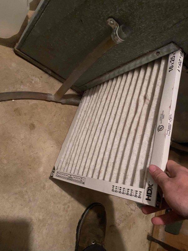 Responded to no cooling complaint on 2019 system with blower not running and no airflow from vents. Upon arrival, inspected electrical panel and found four breakers tripped, then proceeded to HVAC unit for diagnostics. Discovered severely clogged air filter restricting airflow, which likely caused system safety shutdown. Removed and documented dirty 16x25 filter showing significant dust accumulation and discoloration. Measured system temperatures and pressures to verify proper operation after filter replacement. Reset breakers, installed new filter, and restored system to normal cooling operation with proper airflow through vents.
