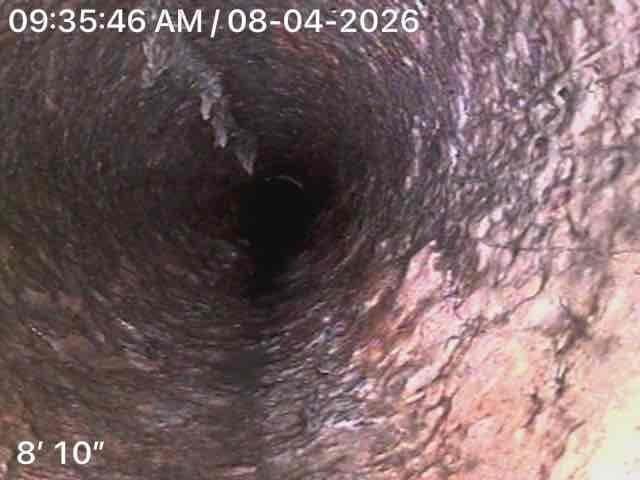 Performed video camera inspection of sewer line in basement as follow-up to previous service call. Camera inspection revealed significant deterioration and buildup throughout the pipe interior, with extensive corrosion, mineral deposits, and discoloration visible on pipe walls at depths ranging from 7'3" to 8'10". Documentation photos captured showing compromised pipe condition with rough, uneven surfaces and substantial accumulation of debris and sediment coating the interior walls.