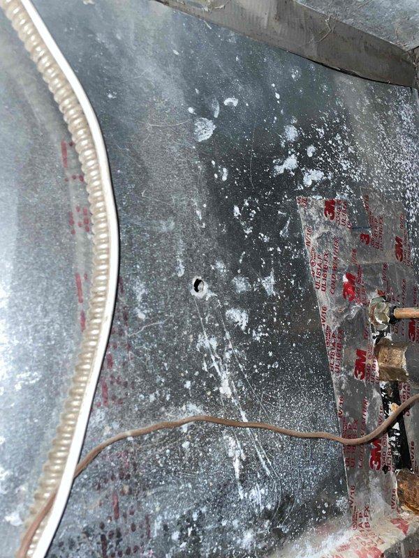 Completed preventive maintenance tune-up on outdoor HVAC unit. Inspected condenser coil and filter assembly, noting accumulated dirt and debris on mesh filters requiring attention. Observed vegetation overgrowth around unit perimeter and dust accumulation on equipment surfaces and refrigerant lines, documented conditions with photos for service records.