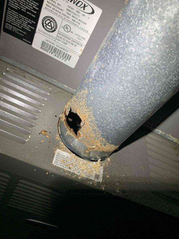 Performed preventive maintenance on 12-year-old Lennox air conditioning system with ground-level condenser unit. Replaced air filter and conducted comprehensive system inspection to identify potential issues. During inspection, discovered significant corrosion at refrigerant line penetration point on cabinet housing, with visible rust damage around connection junction indicating moisture intrusion over time. Observed heavy condensation on suction line insulation, confirming proper refrigerant flow and system operation. Verified all refrigerant line connections, fittings, and insulation integrity. System currently operating within normal parameters despite age-related corrosion on cabinet components.