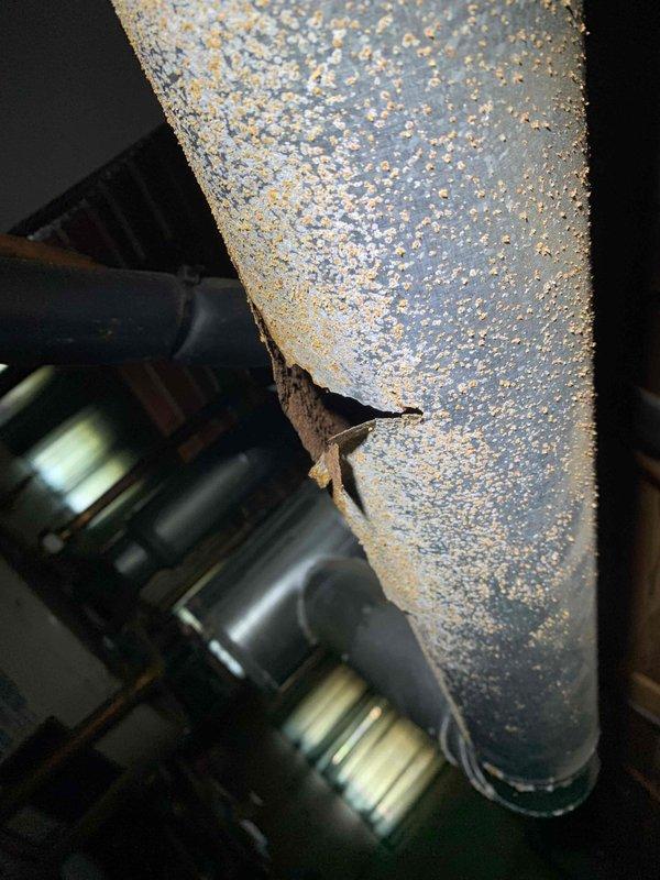 Performed preventive maintenance on 12-year-old Lennox air conditioning system with ground-level condenser unit. Replaced air filter and conducted comprehensive system inspection to identify potential issues. During inspection, discovered significant corrosion at refrigerant line penetration point on cabinet housing, with visible rust damage around connection junction indicating moisture intrusion over time. Observed heavy condensation on suction line insulation, confirming proper refrigerant flow and system operation. Verified all refrigerant line connections, fittings, and insulation integrity. System currently operating within normal parameters despite age-related corrosion on cabinet components.