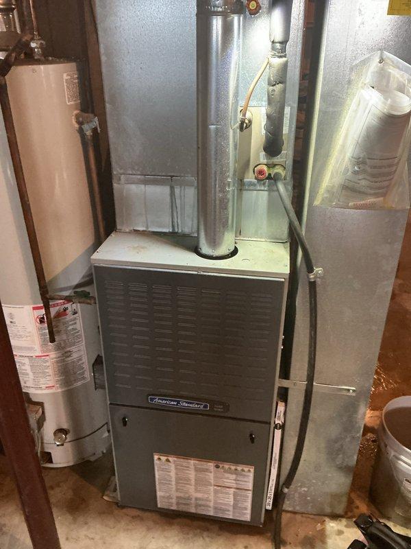 Responded to no cooling call on an 18-year-old residential air conditioning system. Upon arrival, performed diagnostic evaluation of both the outdoor condenser unit mounted on exterior wall bracket and the indoor American Standard furnace with integrated cooling coil. Identified system failure due to age-related component wear. Given the advanced age of the equipment and cost-effectiveness of repair versus replacement, recommended system replacement to restore cooling functionality and improve energy efficiency.