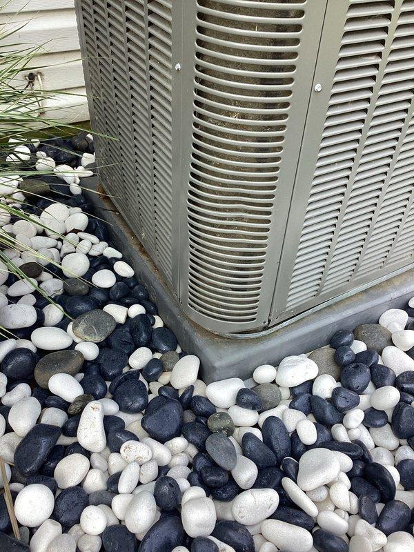 Completed comprehensive cooling system tune-up on 9-year-old residential air conditioning unit. Performed standard maintenance protocol including inspection of condenser coils, refrigerant levels, electrical connections, and overall system operation. Unit is currently positioned on decorative river rock landscaping with adequate clearance; discussed options with customer for improving condenser pad stability and leveling, as unit is currently supported on temporary blocking rather than proper concrete pad foundation.