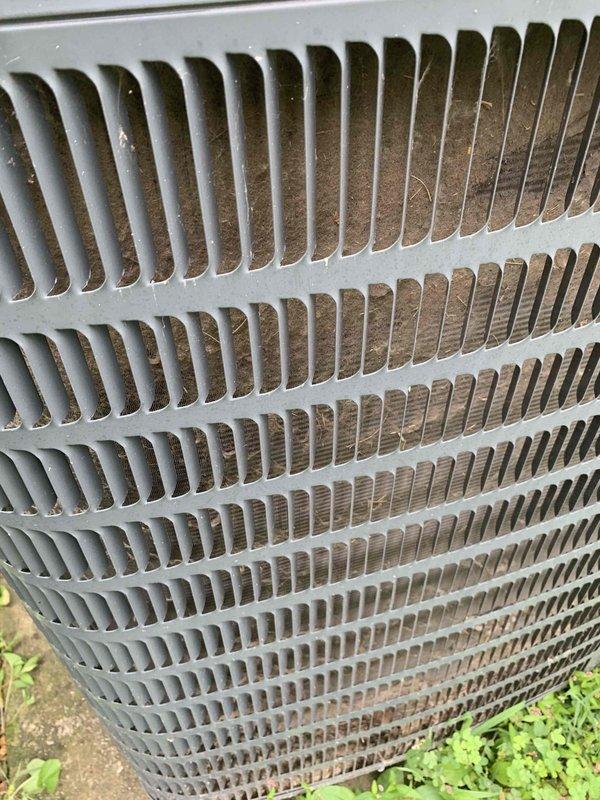 Performed comprehensive HVAC tune-up and maintenance on air conditioning system and furnace with no reported operational issues. Conducted thorough inspection of outdoor condenser unit, which revealed significant accumulation of dirt, dust, and debris on finned coil assembly and protective grille, impacting system efficiency. Cleaned condenser coils and external components to restore proper airflow and heat transfer capability, removing heavy buildup of particulate matter from aluminum fins and louvered protective cover.