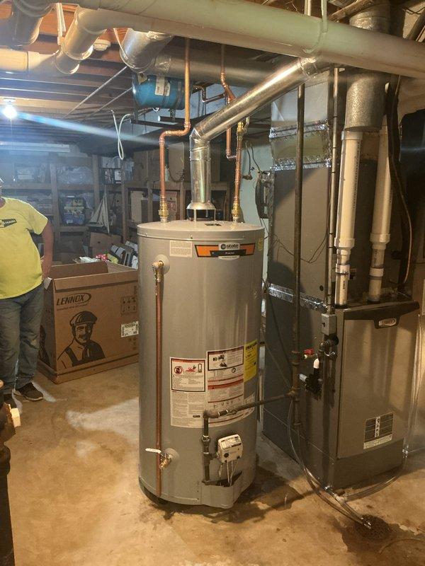 Installed 75-gallon gas tall water heater in basement mechanical room with proper copper piping connections to supply and distribution lines. Equipment was set up per manufacturer specifications with all required safety labels visible, expansion tank secured with metal strapping, and connections to existing HVAC system verified. Permit obtained and installation financed through service financing program.